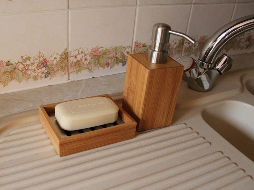 Bamboo lotion dispenser and soap dish in a kitchen